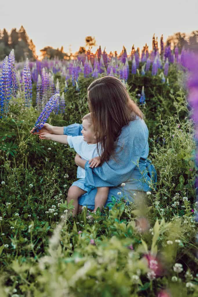 Mother holding child in beautiful field of flowers