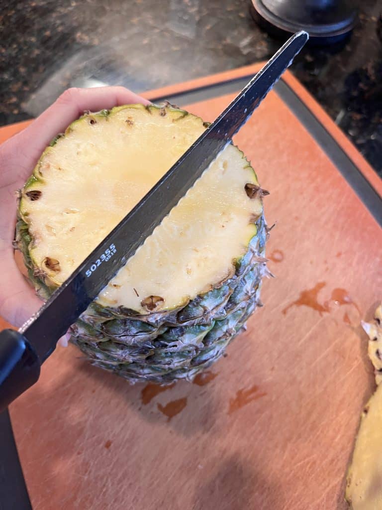 Up close of pineapple being cut along core