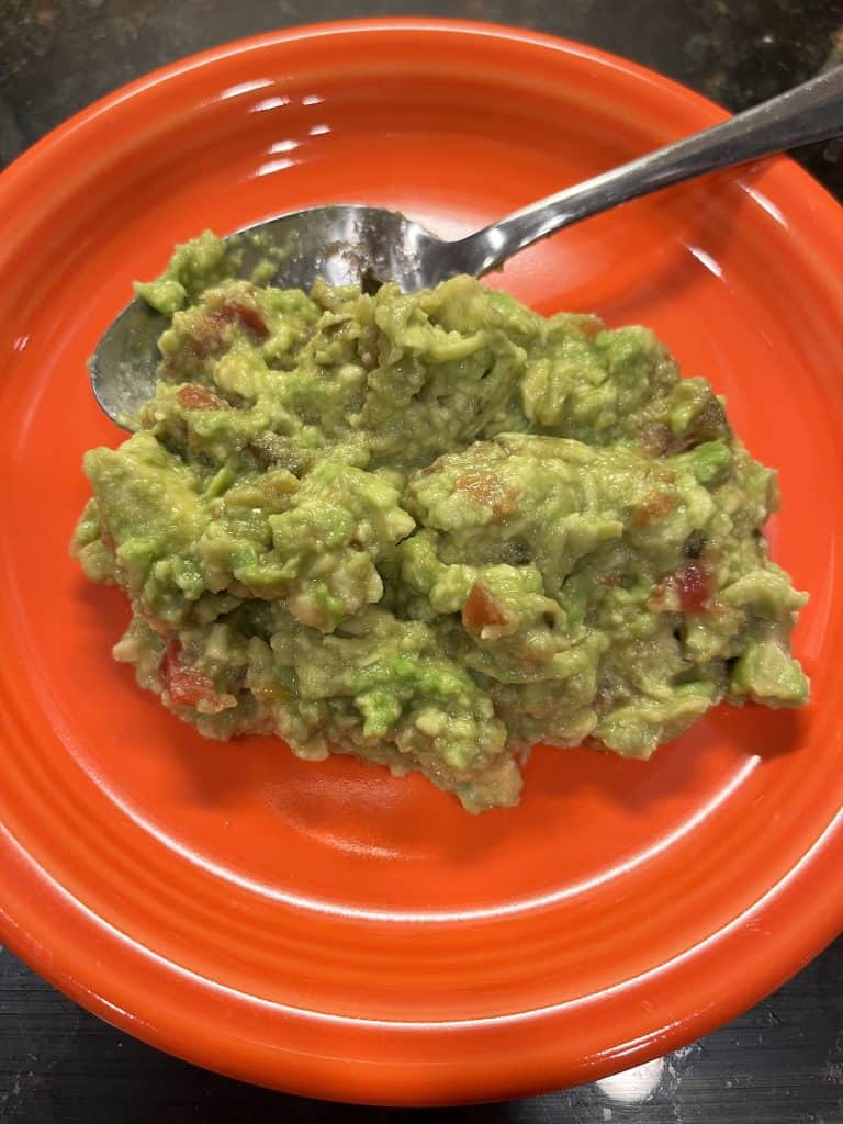 Close up of guacamole on an orange plate