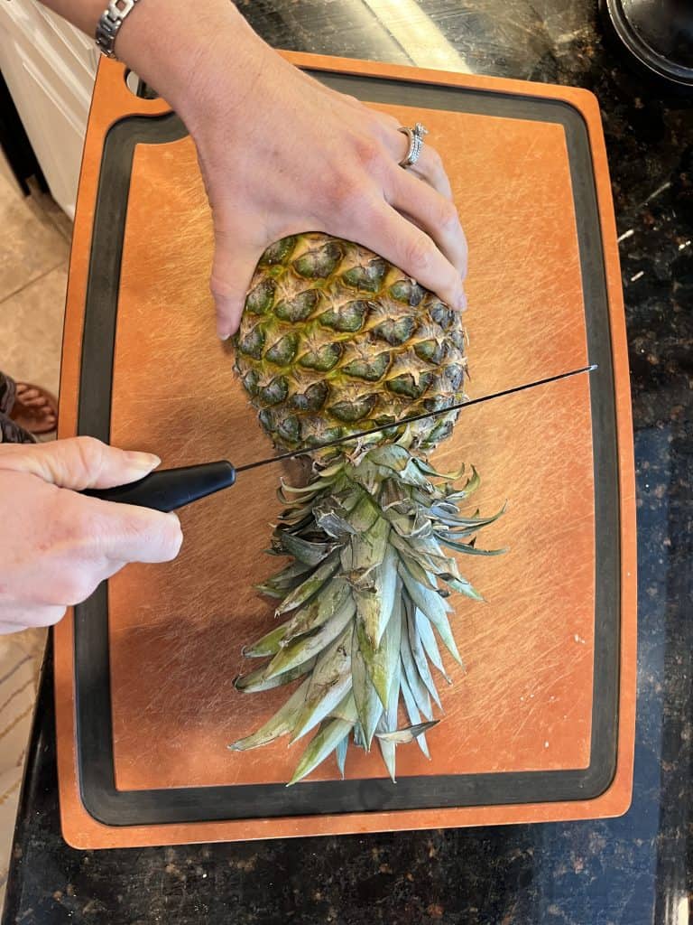 Pineapple on cutting board having stem cut off