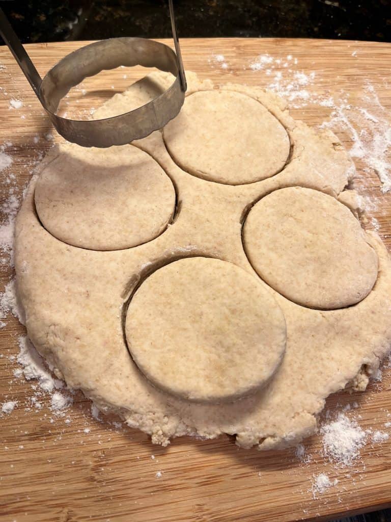 Biscuit dough rolled out and cut into circles with biscuit cutter.