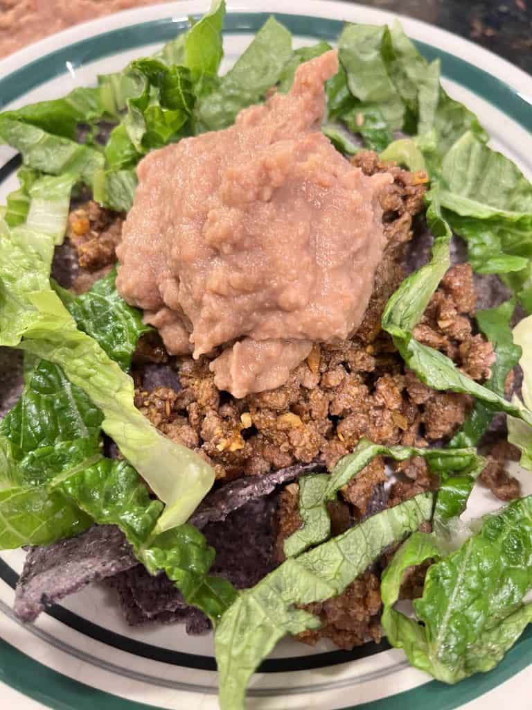 Up close of refried beans surrounded by lettuce