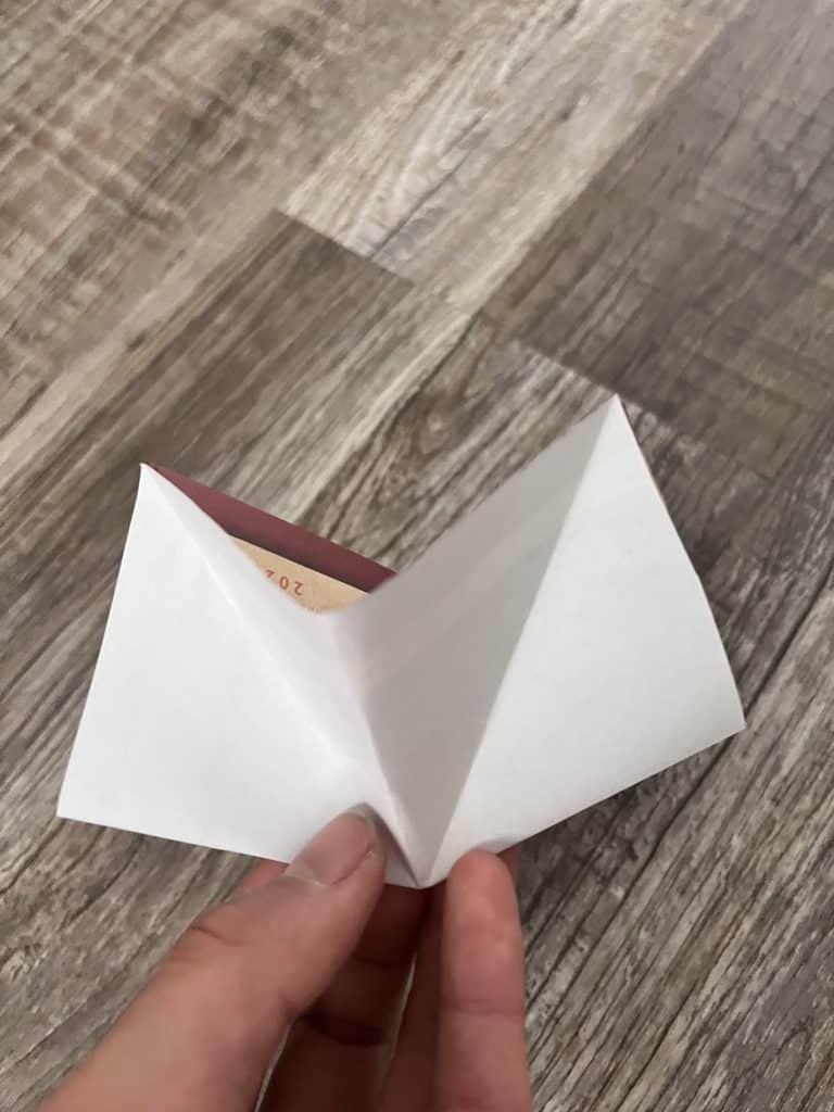 fingers holding folded piece of paper