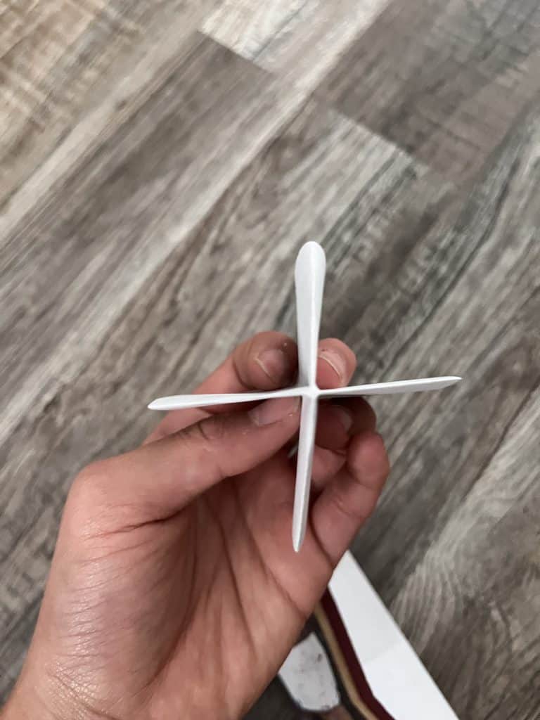 hand holding paper folded to look like propeller blades